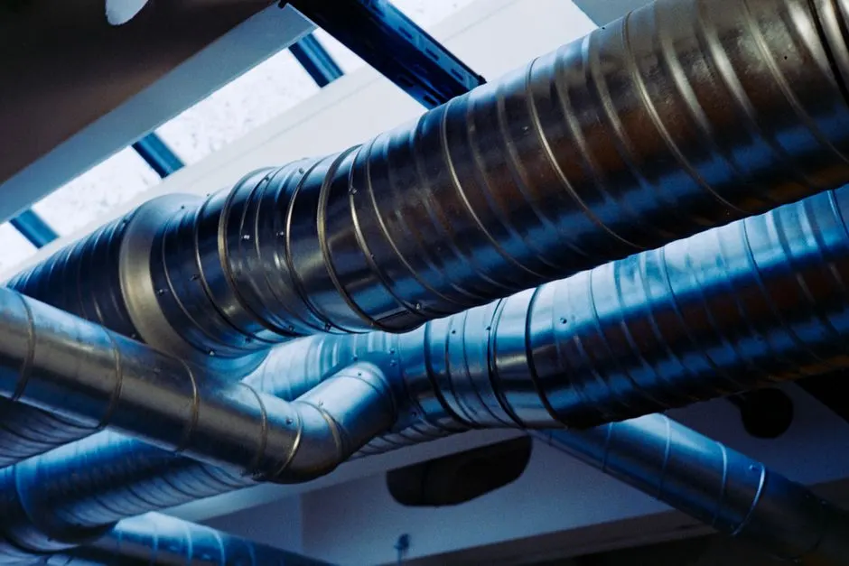 Close-up of a modern metallic ventilation system in an industrial setting.